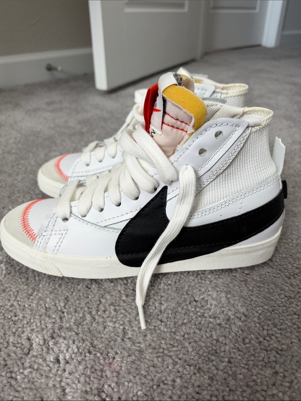 Nike White High-Top Sneakers with Black Swoosh and Yellow Tongue Accent